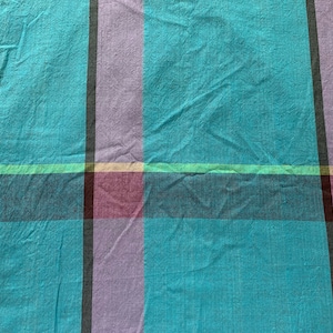 Puede incluir: Primer plano de una tela de cuadros azul, rosa y blanco con una superficie texturizada.