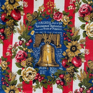 May include: Red, white, and blue fabric with a Liberty Bell design, flowers, and berries. The text "IN CONGRESS, JULY 4 1776 The unanimous Declaration of the thirteen united States of America" is printed on the fabric.