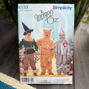 May include: A Simplicity sewing pattern for The Wizard of Oz costumes. The pattern features illustrations of the Scarecrow, the Cowardly Lion, and the Tin Man. The pattern number is 4133, and the sizes are A 3,4,5,6,7,8.