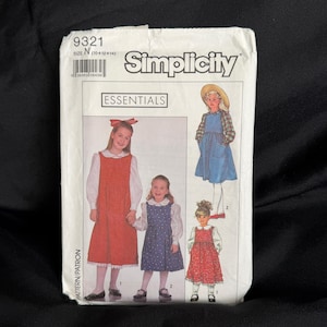 Può includere: Cartamodello Simplicity Essentials, taglia N (10+12+14). La confezione presenta illustrazioni di abiti per bambini in rosso, blu e motivi floreali. Il numero del modello è 9321.