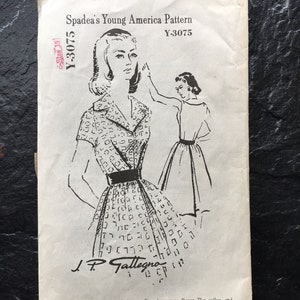 May include: A vintage sewing pattern for a shirtwaist dress with a deep fold in the bodice front and inverted pleats under the skirt. The pattern is from Spadea's Young America Pattern, Y-3075.