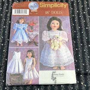 May include: Simplicity sewing pattern for 18 inch dolls. The pattern includes instructions for making three different dresses: a blue dress with lace trim, a white dress with lace trim, and a white dress with a lace overlay. The pattern is titled "Fancy Frocks" and is designed by Bonnie Brown.