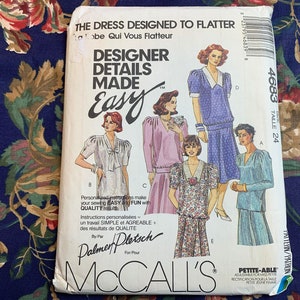 May include: A vintage McCall's sewing pattern envelope for a dress and a top. The pattern is called "Designer Details Made Easy" and is for size 24. The envelope features a photo of four women modeling the garments. The text on the envelope reads "The dress designed to flatter."