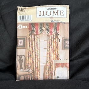 以下が含まれることがあります： Simplicity Home のバランスとパネルの縫製パターン。赤、緑、黄色のアクセントが施されたフローラルデザインです。パッケージには番号 8803 とテキスト「ONE SIZE」が含まれています。