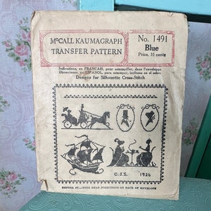 Puede incluir: Patrón de transferencia McCall Kaumagraph vintage, No. 1491, en azul. La portada presenta diseños de siluetas para punto de cruz, incluyendo un carruaje, un barco y figuras en una mesa. El patrón es de 1926.