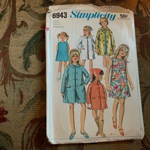 Può includere: Modello di cucito Simplicity numero 6943 per cappotti per bambini. Il modello include quattro diversi stili di cappotti, tra cui un cappotto a quadri, un cappotto a stampa floreale e un cappotto tinta unita. Il modello è per un bambino di taglia 4 con un petto di 58 cm.