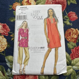 Puede incluir: Un patrón de costura para un vestido sin mangas y una túnica con cuello en V. El patrón es de Vogue Patterns y está etiquetado como "Muy fácil" y "Ajuste personalizado para copas A,B,C,D".