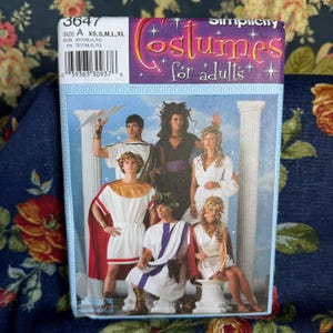 May include: A Simplicity 3647 sewing pattern envelope for adult costumes featuring illustrations of people in ancient Greek and Roman style garments. The package includes sizes XS, S, M, L, and XL, with text reading Costumes for adults.