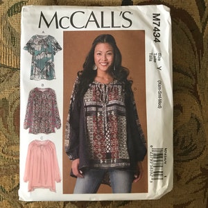 May include: A sewing pattern for a women's blouse with three different styles. The pattern is from McCall's and is size Y (X-Small, Small, Medium). The pattern shows a model wearing a black and red patterned blouse with long sleeves and a gathered neckline.
