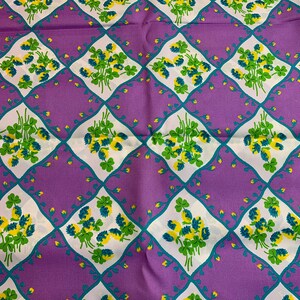 Pu&ograve; includere: Tessuto viola con un motivo a trifoglio bianco e verde. Il motivo a trifoglio si ripete a forma di rombo.