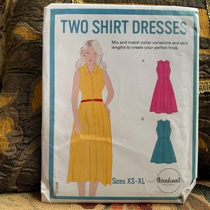 May include: A sewing pattern for two shirt dresses, with illustrations of the dresses in yellow, pink, and teal. The pattern is for sizes XS-XL. The text on the pattern reads "Two Shirt Dresses" and "Mix and match collar variations and skirt lengths to create your perfect frock."