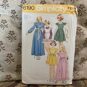 Peut inclure: Patron de couture Simplicity numéro 6190 pour une robe de fille. Le patron comprend quatre styles de robes différents, dont une robe à manches longues avec un col à volants, une robe sans manches avec un bavoir, une robe à manches courtes avec un volant et une robe à manches longues à carreaux.