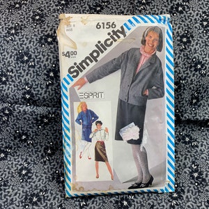 May include: Simplicity sewing pattern number 6156 for a jacket and skirt. The pattern is for sizes 8 to 18. The model is wearing a gray jacket and a black skirt. The pattern is for Esprit.