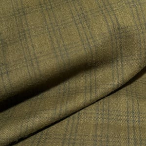 May include: Close-up of a green fabric with a subtle woven pattern. The fabric has a soft, textured feel.