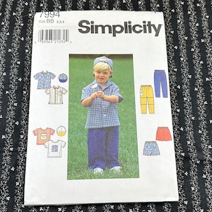 Könnte beinhalten: Simplicity Schnittmuster Nummer 7994 für Jungenbekleidung. Das Schnittmuster enthält Anleitungen zum Nähen eines kurzärmeligen Hemdes, eines langärmeligen Hemdes, einer Hose, einer Shorts und einer Mütze. Das Schnittmuster ist mit einem jungen Jungen illustriert, der ein blau-weiß kariertes Hemd, eine blaue Hose und eine blau-weiße Mütze trägt.