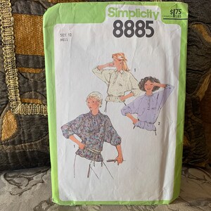 May include: A Simplicity sewing pattern envelope with the number 8885 printed on the front. The pattern is for a blouse and includes three different styles. The envelope is green and white and has a price tag of $1.75.