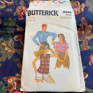 May include: Vintage sewing pattern for a women's shirt. The pattern is from Butterick and is number 6956. The pattern is for size 10 and costs $2.49. The pattern shows three different styles of shirts, one in blue, one in pink, and one in plaid.