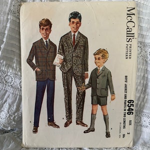 Może przedstawiać: Wzorzec szycia vintage McCall's do kurtki i spodni dla chłopców w dwóch długościach. Wzorzec jest wydrukowany na białym papierze z czarnym tekstem i ilustracjami trzech chłopców ubranych w ubrania. Numer wzorca to 6546, a rozmiar to 2.