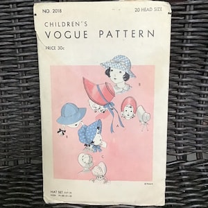 Puede incluir: Patrón de costura vintage Vogue para niños para un conjunto de sombreros. El patrón es para las tallas 19-20-21-22 e incluye cuatro estilos de sombreros diferentes. El patrón está impreso en papel blanco con un fondo rosa e ilustraciones de niños usando los sombreros.