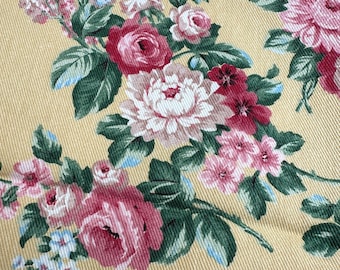 May include: Floral fabric with a repeating pattern of pink and red roses, peonies, and other flowers on a yellow background. The leaves are green with blue accents. The fabric has a textured appearance.