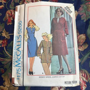 Puede incluir: Patrón de costura vintage McCall's 5266 para vestido, jumper o top de mujer. El patrón presenta ilustraciones de las prendas en diseños azules, rojos y a rayas. El patrón incluye el texto "Quick & Easy" y "Carefree Patterns".
