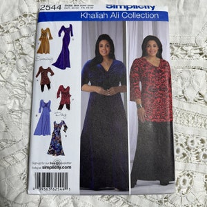Puede incluir: Un patrón de costura para un vestido con dos estilos diferentes: un vestido largo de terciopelo azul con cuello en V y un vestido más corto con estampado rojo y negro con cuello en V. El patrón es de Simplicity y forma parte de la colección Khaliah Ali. El número del patrón es 2544.