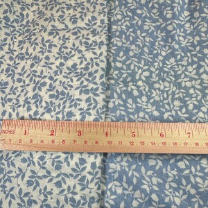 May include: Two fabric swatches with a white background and a blue floral pattern. A ruler is placed across the swatches, showing the measurement in inches.