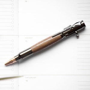 Walnut Bolt Action Pen resting on top of a planner page.