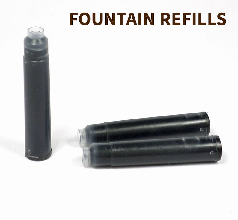 May include: Three black fountain pen ink cartridges with clear plastic ends. The text "FOUNTAIN REFILLS" is printed in brown at the top of the image.