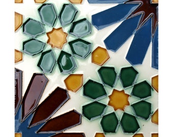 May include: A square ceramic tile with a geometric pattern in shades of blue, green, brown, and yellow. The tile features a repeating starburst design with intricate details.