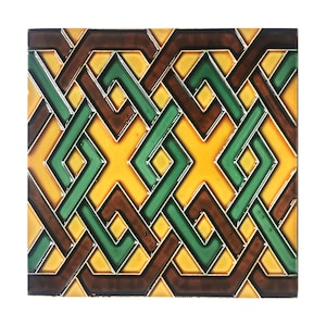 Può includere: Una piastrella di ceramica con un motivo geometrico in tonalità di marrone, giallo e verde. Il motivo è composto da quadrati e rombi intrecciati.