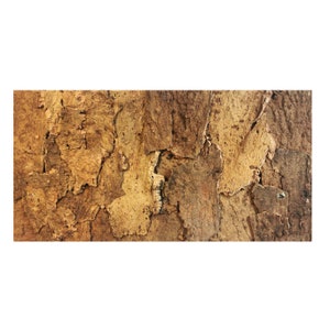 May include: Close-up of a textured, natural cork surface. The cork has a mix of light and dark brown tones, with a rough, uneven texture. The surface is made up of irregular shapes and patterns, creating a rustic appearance.