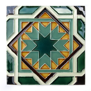 May include: Square ceramic tile with a geometric star pattern. The tile features a central dark green star surrounded by teal, brown, and yellow shapes, framed by white and dark green borders. The design is symmetrical and intricate.