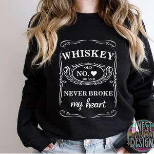 May include: Black sweatshirt with a white graphic design of a whiskey bottle label that says "Whiskey Old No. Brand Never Broke My Heart".
