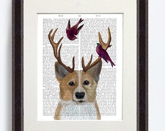 May include: A framed print of a corgi with antlers and three birds perched on the antlers. The print is on a white background with black text. The frame is dark brown wood.