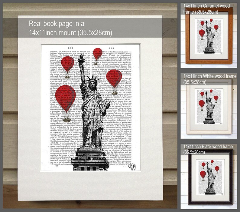 May include: A black and white illustration of the Statue of Liberty with red hot air balloons flying above her. The illustration is printed on a book page and framed in a white wood frame. The frame is 14 inches by 11 inches and measures 35.5 cm by 28 cm.