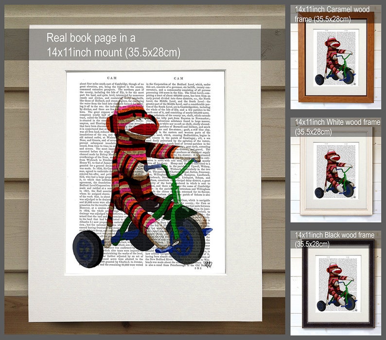 May include: A red and white striped sock monkey riding a green tricycle on a book page. The book page is framed in a 14x11 inch caramel wood frame. The image is also shown in white and black wood frames.