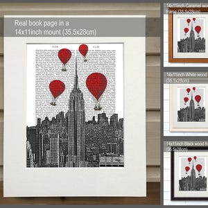 K&ouml;nnte beinhalten: Eine Schwarzwei&szlig;illustration der Skyline von New York City mit roten Hei&szlig;luftballons, die dar&uuml;ber schweben. Die Illustration ist auf einer Buchseite gedruckt und in einem 35,5 x 28 cm gro&szlig;en Karamellholzrahmen gerahmt.
