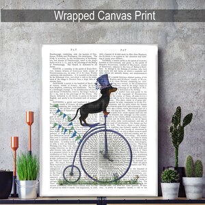 May include: A black and tan dachshund wearing a blue top hat and riding a blue and white penny-farthing bicycle. The background is a vintage book page with text about the history of the town of Patney, England.