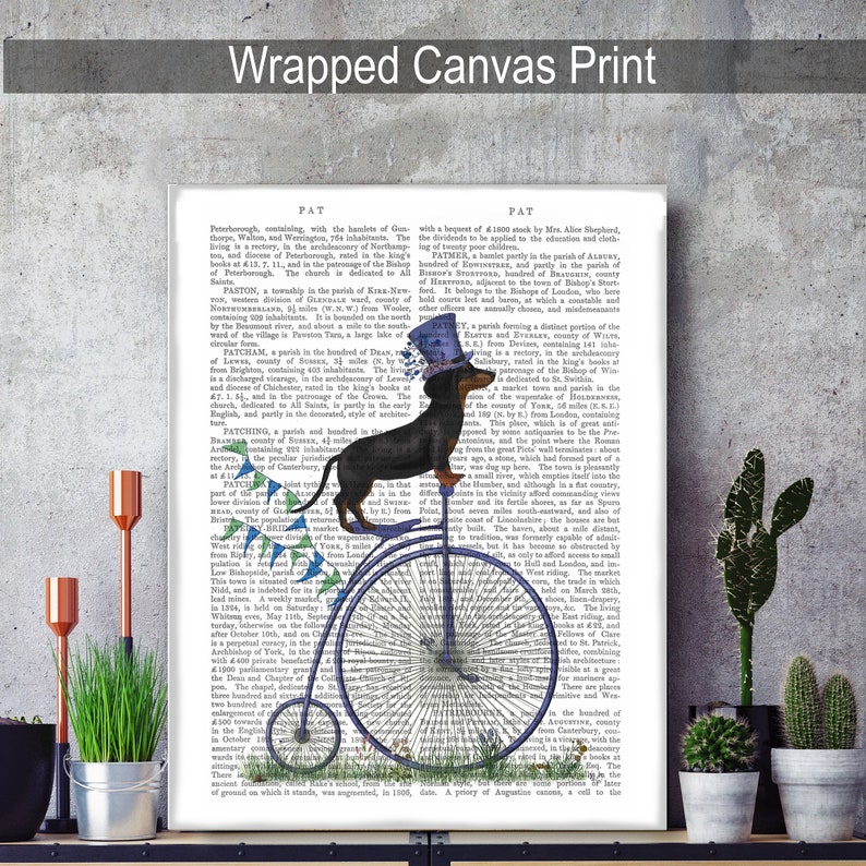 May include: A black and tan dachshund wearing a blue top hat and riding a blue and white penny-farthing bicycle. The background is a vintage book page with text about the history of the town of Patney, England.