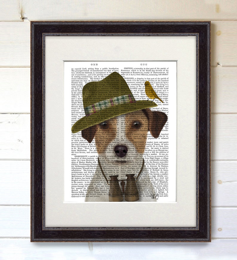May include: A brown and white dog wearing a green and brown hat with a plaid band and holding binoculars. The dog is looking at the camera. The background is a vintage book page with text.