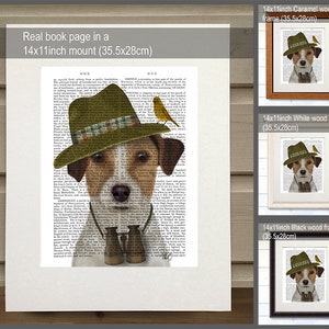 May include: A Jack Russell terrier wearing a green and brown hat, a necktie, and binoculars. The dog is standing on a book page with text. The image is framed in a caramel wood frame. The image is also available in white and black wood frames.