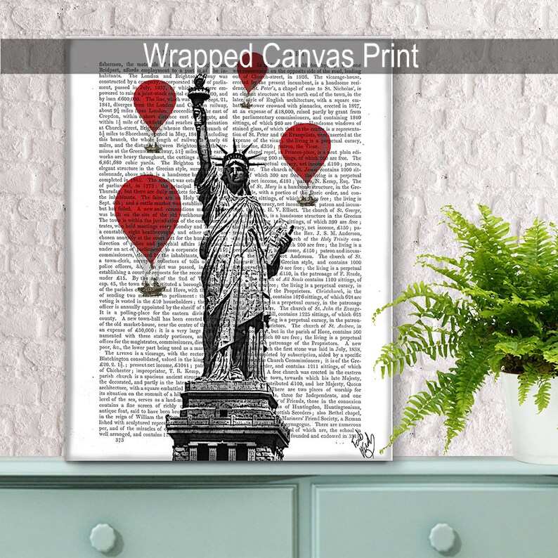 May include: A black and white illustration of the Statue of Liberty with red hot air balloons floating above her. The illustration is printed on a page of a vintage book.