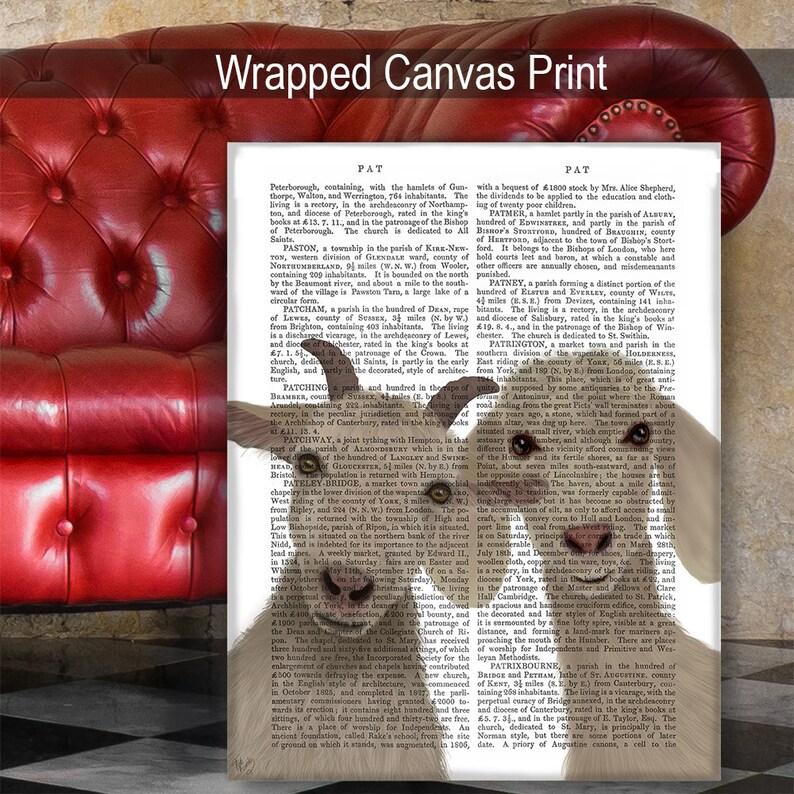 May include: A white goat with brown eyes and a black nose is looking at the camera. The goat is in front of a page of text from an old book. The text is about the history of the town of Patrington, England. The text is in black and white and is printed in a serif font.