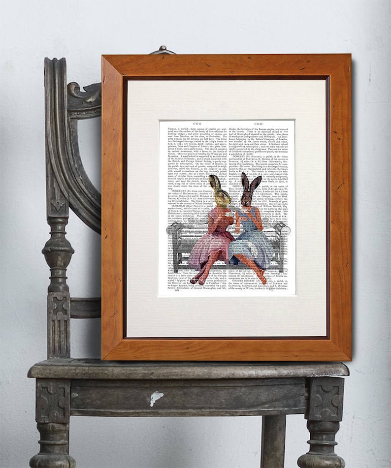May include: Two women with bunny ears sit on a park bench and drink tea. The image is printed on a page of a vintage book.