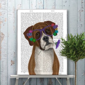 May include: A brown and white boxer dog wearing purple glasses and a flower crown. The dog is holding a purple flower in its mouth. The dog is in front of a page of text from a book.