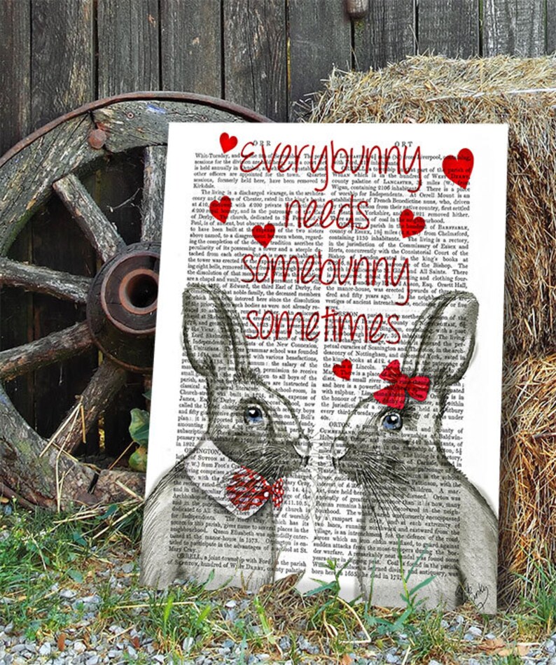 May include: A black and white illustration of two bunnies with red hearts and a red bow on one bunny. The text "Everybunny needs somebunny sometimes" is printed on a vintage book page background.