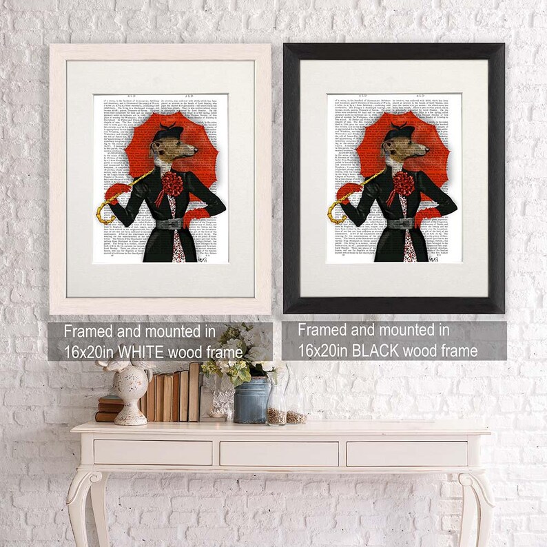 May include: Two framed prints of a dog wearing a red hat and holding a red umbrella. The print on the left is framed in white and the print on the right is framed in black. Both prints are 40.64cm x 50.8cm.