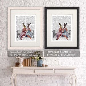 May include: Two framed prints of a vintage illustration of two rabbits wearing dresses and hats, sitting on a bench and drinking tea. The prints are framed in white and black wood frames. The text on the frames reads "Framed and mounted in 16x20in WHITE wood frame" and "Framed and mounted in 16x20in BLACK wood frame".