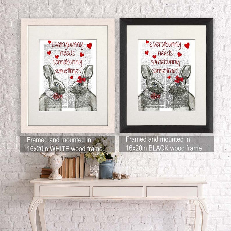 May include: Two framed prints of a black and white illustration of two bunnies with red bows. The text on the prints reads "Everybunny needs somebunny sometimes". The prints are framed in white and black wood frames. The frames are 16 inches by 20 inches.